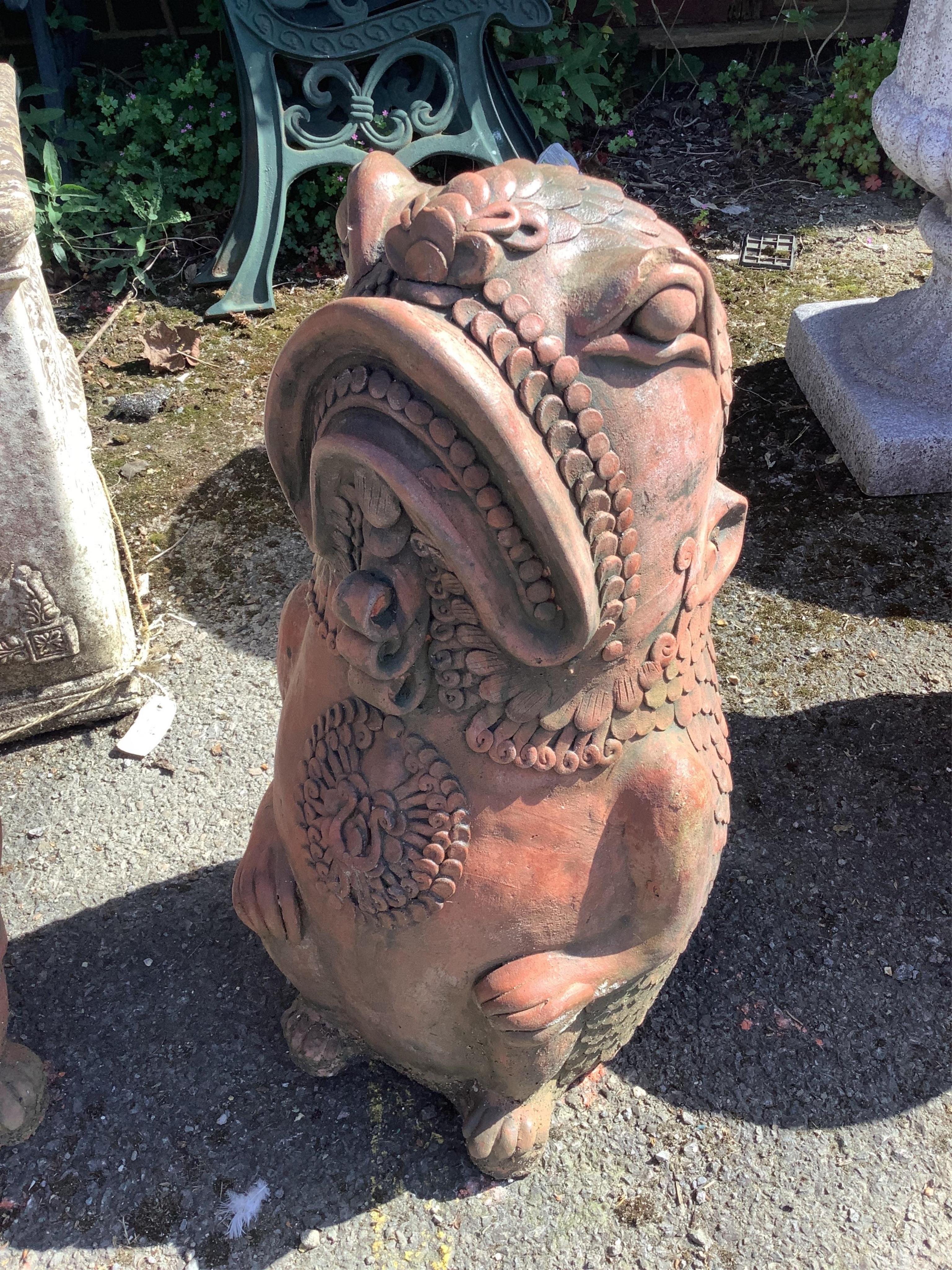A pair of cast terracotta Oriental fish garden ornaments, height 61cm